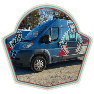 Blue van with cartoon plumber graphics parked on gravel, trees in background, badge-shaped frame around the image.